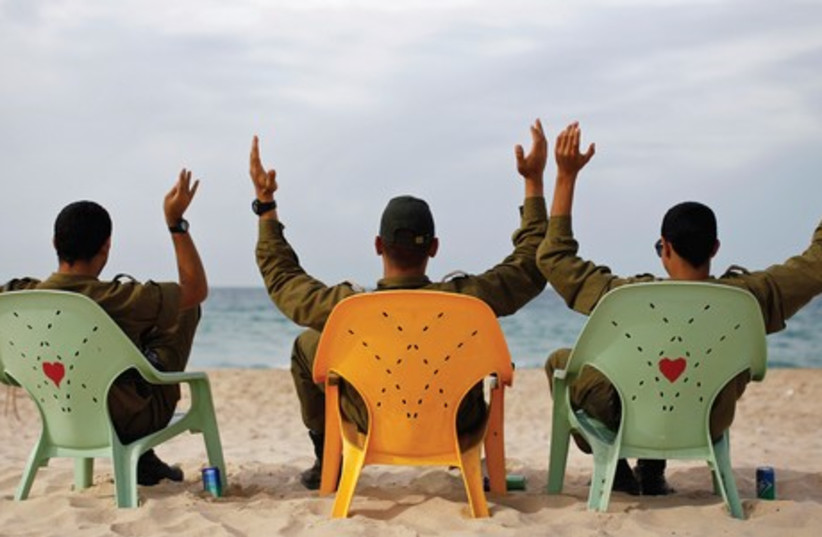 SOLDIERS TAKE a break on Zikim Beach, near Ashkelon. (photo credit: REUTERS)