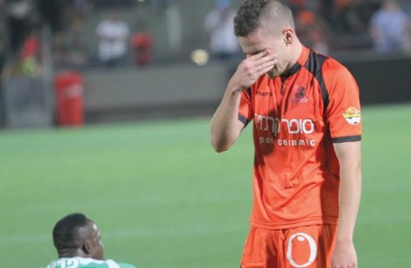 Bnei Yehuda forward Amir Agajev (right) left the pitch in tears Saturday night after his team was relegated from the Premier League. (photo credit: ADI AVISHAI)