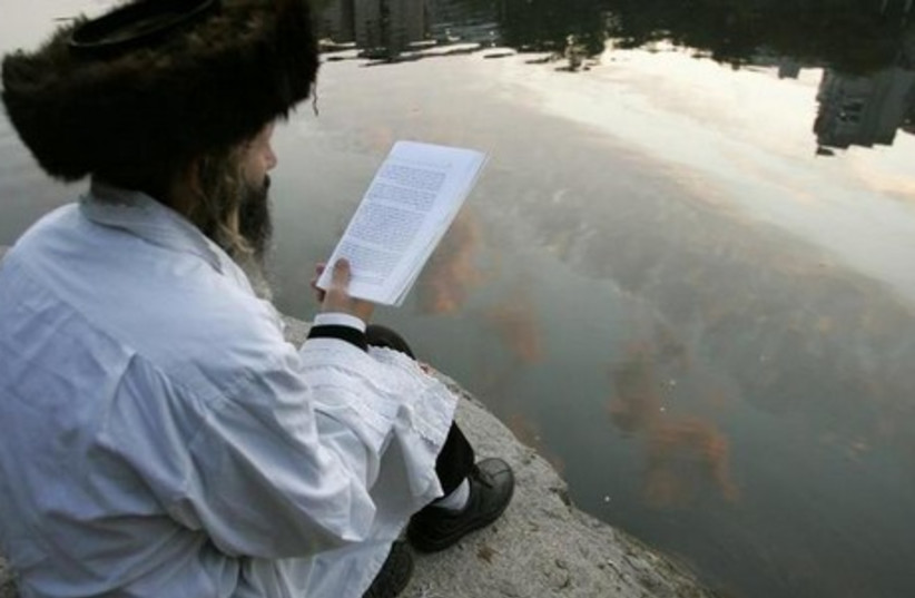 Orthodox Jew reads at a lake in Uman, Ukrainian (photo credit: REUTERS)