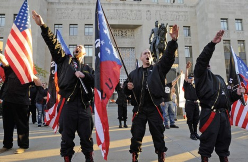 Members of the US National Socialist Movement salute during a neo-Nazi rally in Kansas City on the 75th anniversary of the Kristallnacht attack on Jews in Germany (photo credit: DAVE KAUP / REUTERS)