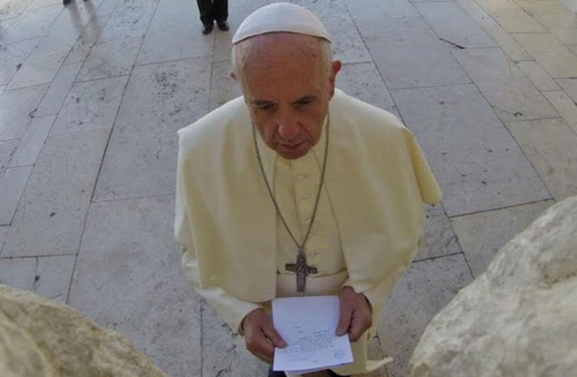 Pope Francis sticks a note in the Western Wall (photo credit: GPO)