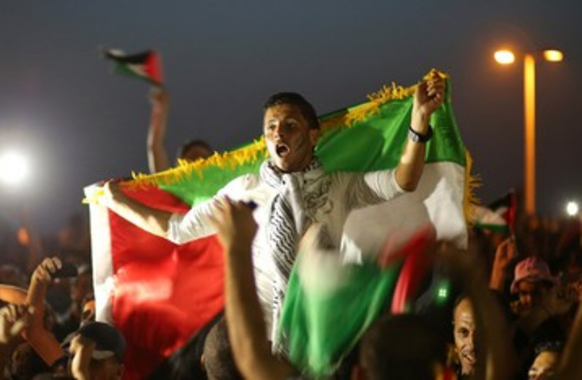 Palestinians celebrate after their national soccer team defeated the Philippines during their AFC Cup final soccer match, in Gaza City May 30, 2014 (photo credit: REUTERS)