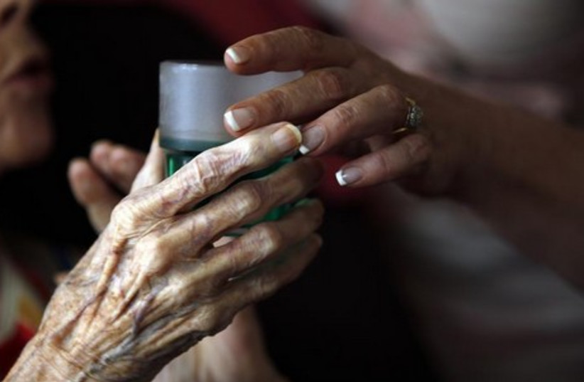 Nurse gives medication to elderly patient [Illustrative] (photo credit: REUTERS)