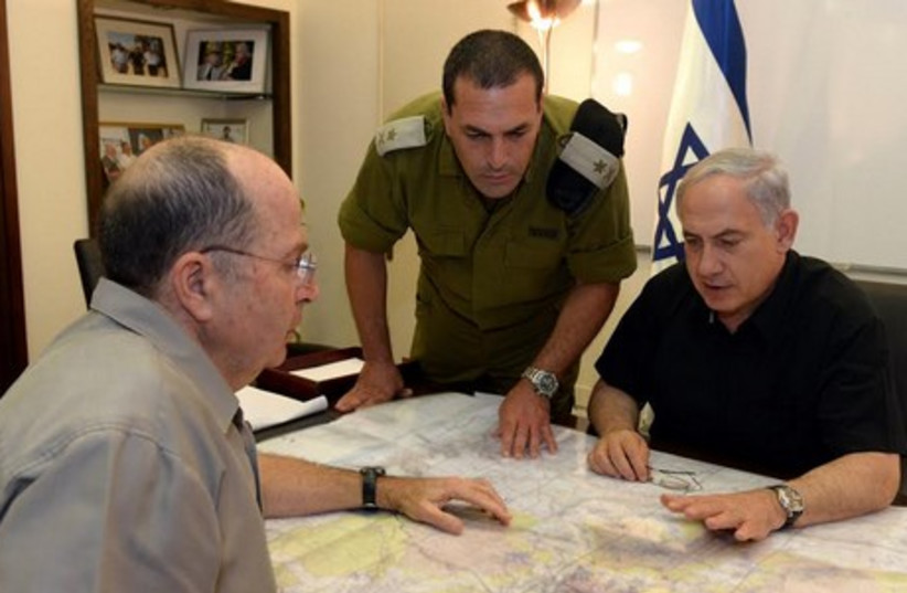 Prime Minister Binyamin Netanyahu (R), an IDF officer, and Defense Minister Moshe Ya'alon at the Kiryat Defense Ministry Compound in Tel Aviv. (photo credit: GPO)