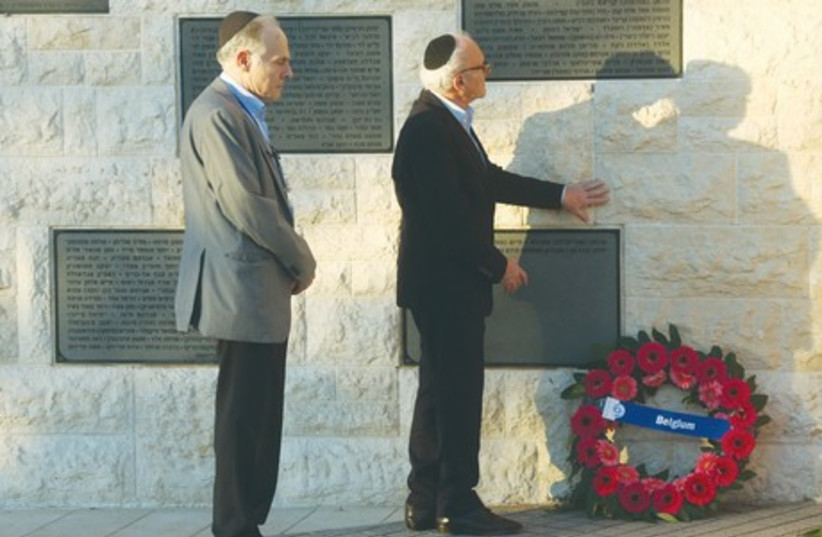 Eli Ringer (left), of the Flemish Forum of Jewish Organizations, and Baron Julien Klener, president of the Consistoire Central Israèlite de Belgique, honor the memory of those killed at the Jewish Museum shooting in Brussels during a ceremony on Mount Herzl. (photo credit: MARC ISRAEL SELLEM/THE JERUSALEM POST)
