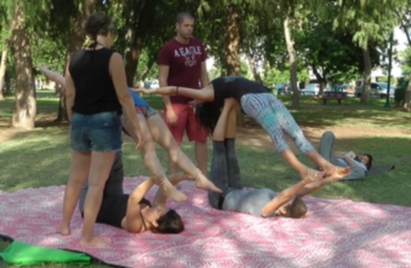 The Neshama Project practiced acroyoga in HaYarkon Park. The retreat brought in Israeli yoga instructors in addition to having Tratt leading daily yoga routines.  (photo credit: JENNY TINTNER)
