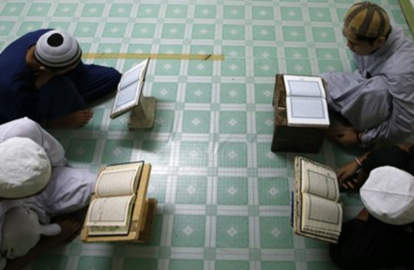 Filipino Muslim students read the Koran in a classroom next to the Blue Mosque ahead of the holy fasting month of Ramadan in Taguig, Metro Manila. (photo credit: REUTERS)