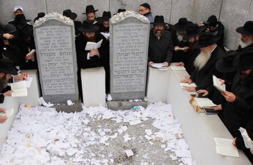 People pray at the gravesite of the Lubavitcher Rebbe, Rabbi Menachem M. Schneerson, in the Queens borough of New York. (photo credit: REUTERS)