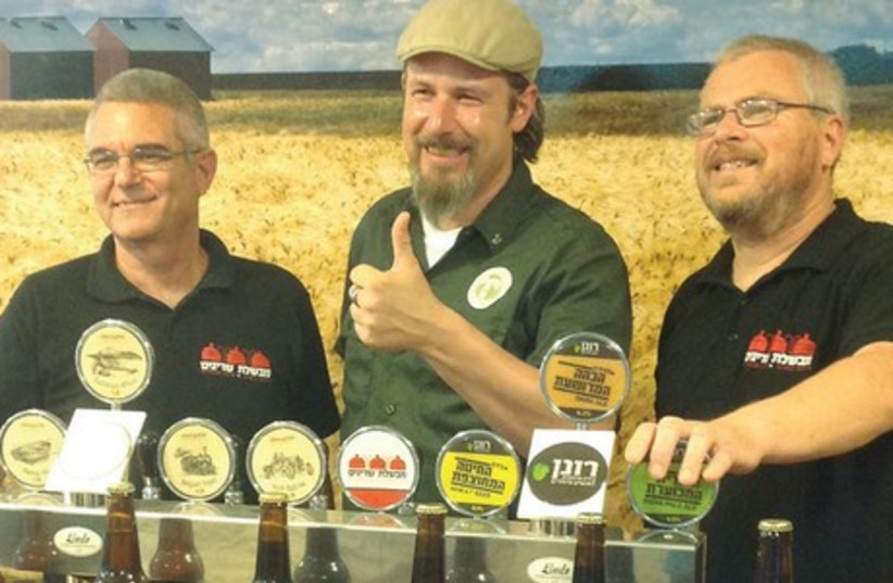 Oliver Wesseloh posing with the two founders of Srigim Brewery (photo credit: LIA KAMANA)