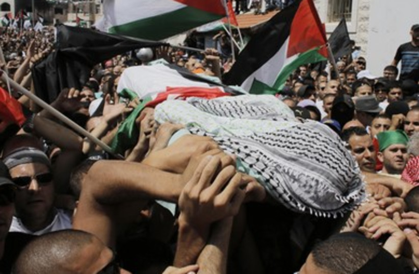 Palestinians carry the body of 16-year-old Muhammad Abu Khdeir during his funeral in Shuafat. (photo credit: REUTERS)