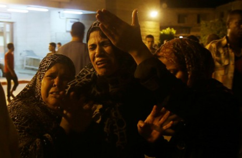 Women mourn after an Israeli air strike killed two Palestinian militants, at a hospital morgue in the central Gaza Strip July 6, 2014. (photo credit: REUTERS)