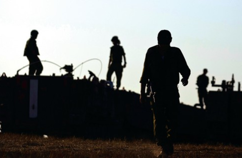 Ready for action: IDF troops just outside the southern Gaza Strip, July 6 (photo credit: AMIR COHEN - REUTERS)