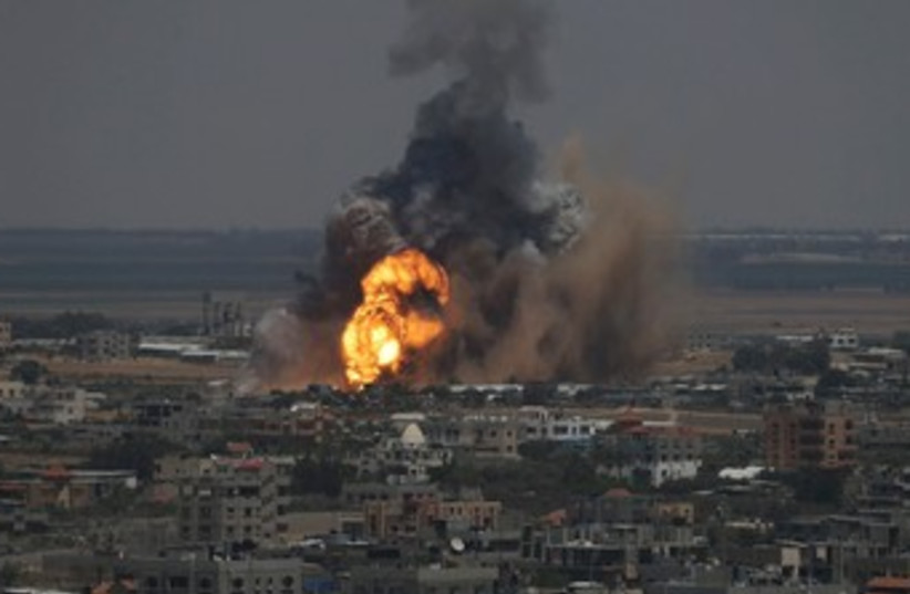 Smoke and flames are seen following what police said was an Israeli air strike in Rafah in the southern Gaza Strip July 8, 2014. (photo credit: REUTERS)