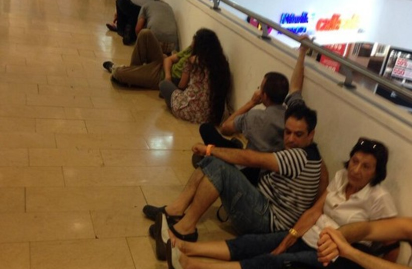 People at Dizengoff Center waiting for the all clear (photo credit: NIV ELIS)