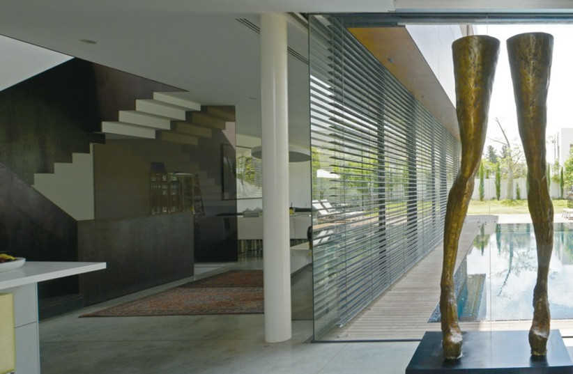 A simple and vibrant statue of legs, by artist Eran Shakin, is visible through the picture window from the swimming pool. (photo credit: URIEL MESSA)
