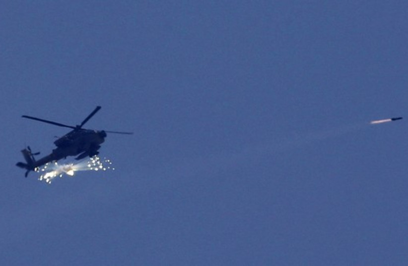 An Israeli Apache helicopter fires a missile towards the northern Gaza Strip (photo credit: REUTERS)