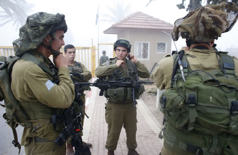 Israeli soldiers prepare for a patrol just outside the Gaza Strip (photo credit: REUTERS)