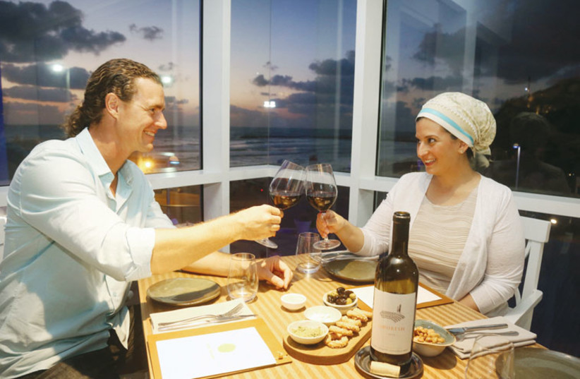 Tom Franz cheers his wife, Dana, over an intimate dinner in Tel Aviv’s Lumina restaurant. (photo credit: MARC ISRAEL SELLEM/THE JERUSALEM POST)