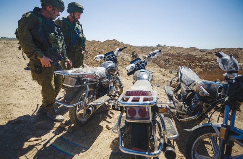 SOLDIERS EXAMINE three motorcycles discovered last week in a tunnel in the Karni crossing area that terrorists intended to use in an attack on communities near the Gaza border. (photo credit: IDF)
