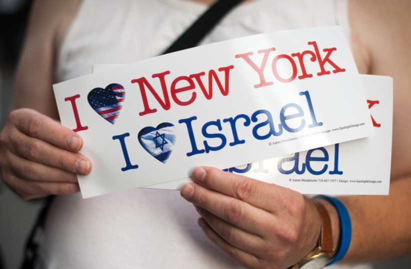 A pro-Israel demonstrator holds up stickers. (photo credit: ANNA HIATT)