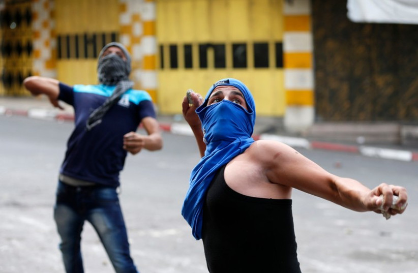 Palestinian protesters hurl stones towards IDF troops during clashes at a protest against the Israeli offensive in Gaza, in the West Bank City of Hebron August 9, 2014. (photo credit: REUTERS)