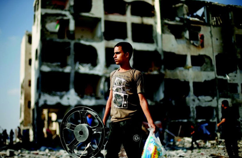Jeune Palestinien de Beit Lahiya devant son immeuble en ruine (photo credit: REUTERS)