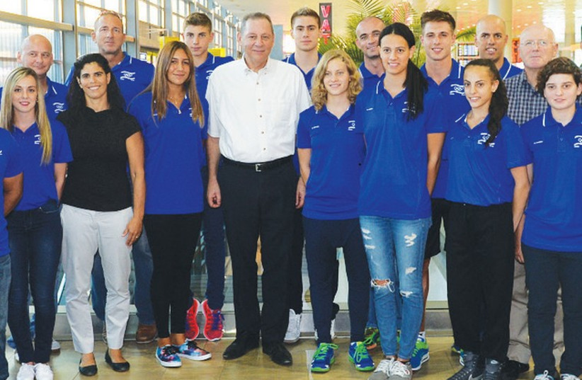 Israel’s 14-athlete delegation to the second Summer Youth Olympic Games poses with Olympic Committee of Israel President Igal Carmi (center). (photo credit: OLYMPIC COMMITTEE OF ISRAEL)