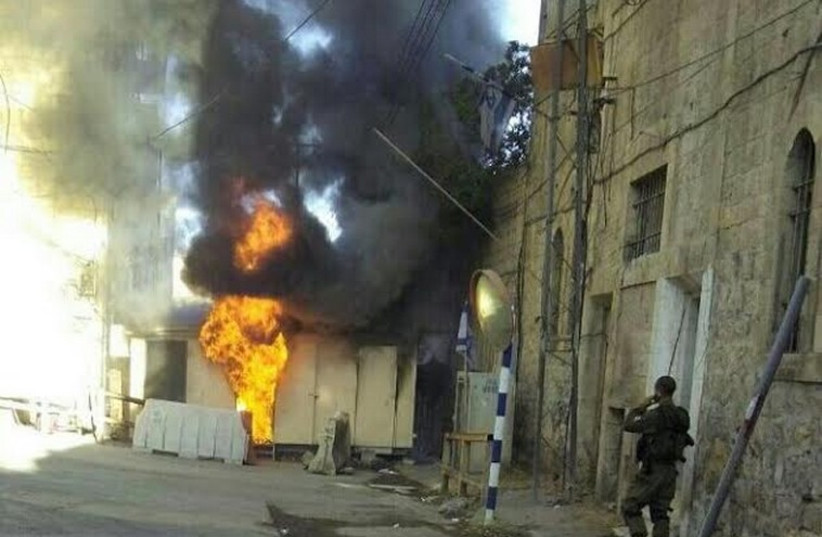 IDF checkpoint catches fire after fire bomb attack. (photo credit: JEWISH COMMUNITY OF HEBRON)