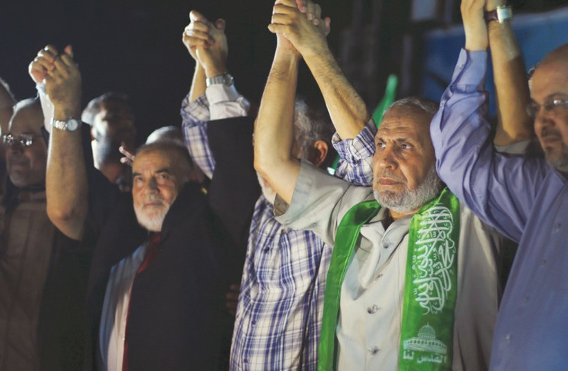 SENIOR HAMAS LEADER Mahmoud Zahar (second right), appearing in public for the first time since the 50-day began, attends a rally in Gaza City celebrating the cease-fire that began yesterday evening. (photo credit: REUTERS)