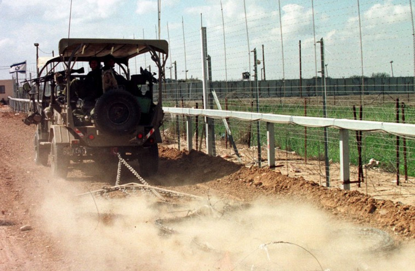 IDF vehicle drives along Gaza border fence [file] (photo credit: REUTERS)