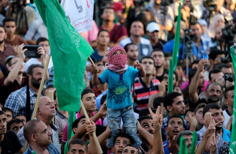 Hamas supporters celebrate with people what they said was a victory over Israel in Gaza City, August 27 (photo credit: REUTERS)