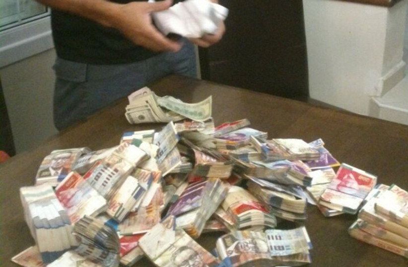 Cocaine, heroine and cash seized by police from drug dealers during an early morning Wednesday raid in southern Israel. (photo credit: ISRAEL POLICE)