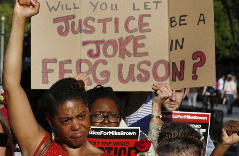 Protesters call for a thorough investigation of the shooting death of teen Michael Brown in Ferguson, Missouri, on a street in front of the White House in Washington. (photo credit: REUTERS)