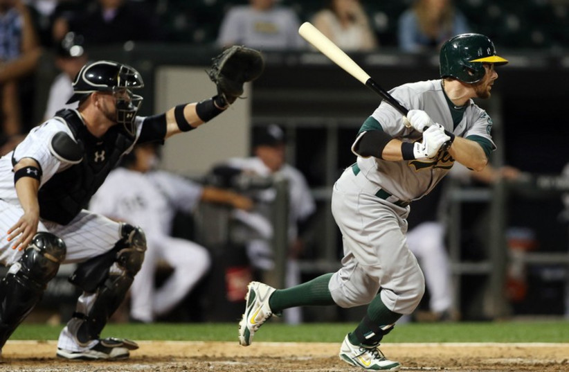 Chicago, IL, USA; Oakland Athletics second baseman Eric Sogard hits a two-run single against the Chicago White Sox during the ninth inning at US Cellular Field. (photo credit: REUTERS)