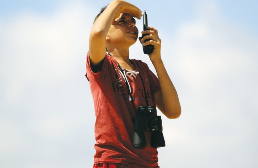 a 14-year-old Syrian, uses a walkie-talkie at an observation post to locate the positions of forces loyal to Syria’s President Bashar Assad (photo credit: REUTERS)