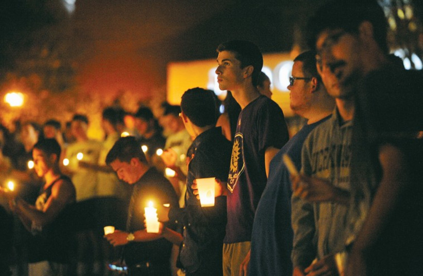 Students hold candles during a vigil honoring US journalist Steven Sotloff at the Reflection Pool on the campus of his alma mater, the University of Central Florida in Orlando. (photo credit: REUTERS)