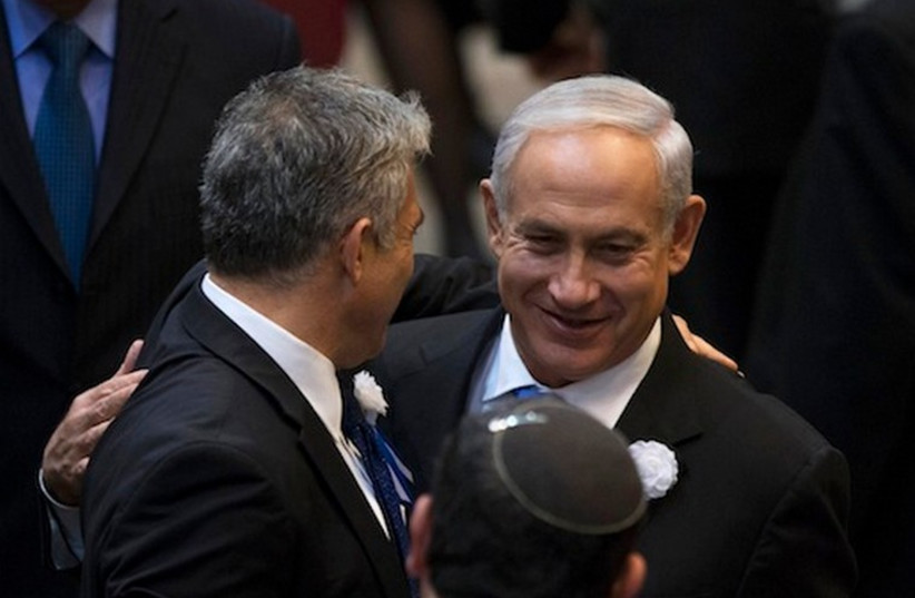 Prime Minister Binyamin Netanyahu (R) and Finance Minister Yair Lapid embrace in the Knesset. (photo credit: REUTERS)