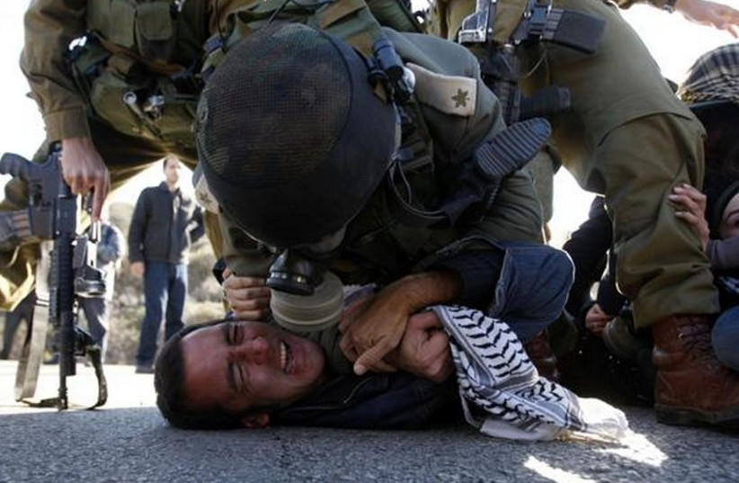 IDF soldiers detain an activist near the West Bank town of Ramallah. (photo credit: REUTERS)