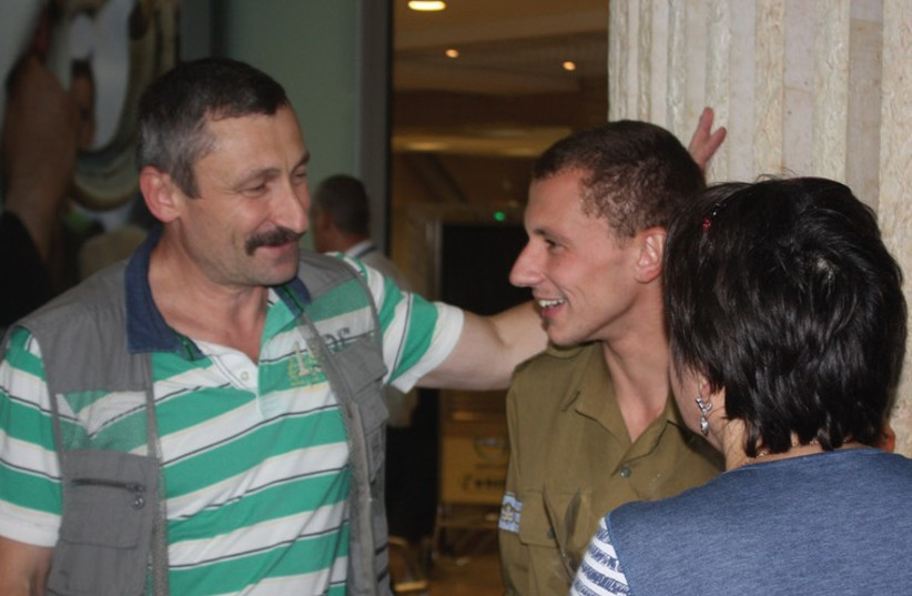 LONE SOLDIER Maksim Kolesnikov reunites yesterday at Ben-Gurion Airport with his newly arrived parents. (photo credit: EITAN AROM)