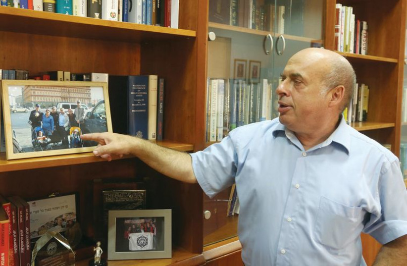 Natan Sharansky points to a photo of his family, taken outside former KGB headquarters in Moscow, at his office in Jerusalem. (photo credit: MARC ISRAEL SELLEM/THE JERUSALEM POST)