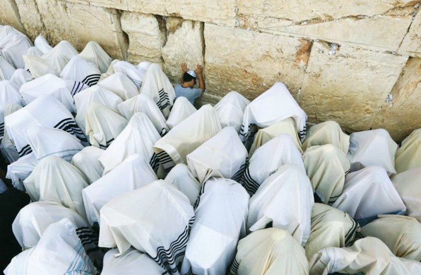 The synchronicity of the priestly blessing is momentarily broken by the appearance of a young boy, praying at the Western Wall, in September 2013. (photo credit: MARC ISRAEL SELLEM/THE JERUSALEM POST)