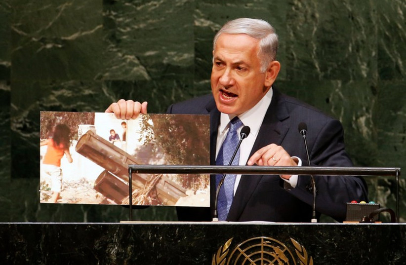 Israel's Prime Minister Benjamin Netanyahu holds up a photograph as he addresses the 69th United Nations General Assembly (photo credit: REUTERS)