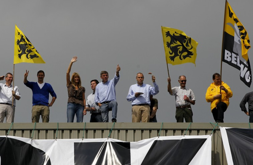 Belgium's Flemish right wing Vlaams Belang party leader Filip Dewinter and supporters wave Flemish flags (photo credit: REUTERS)