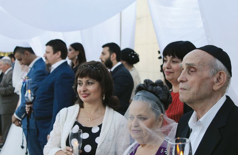 Jewish couples some of them refugees, gather for a mass wedding ceremony, to be married according to Jewish law under the auspices of Chabad. (photo credit: SAM SOKOL)