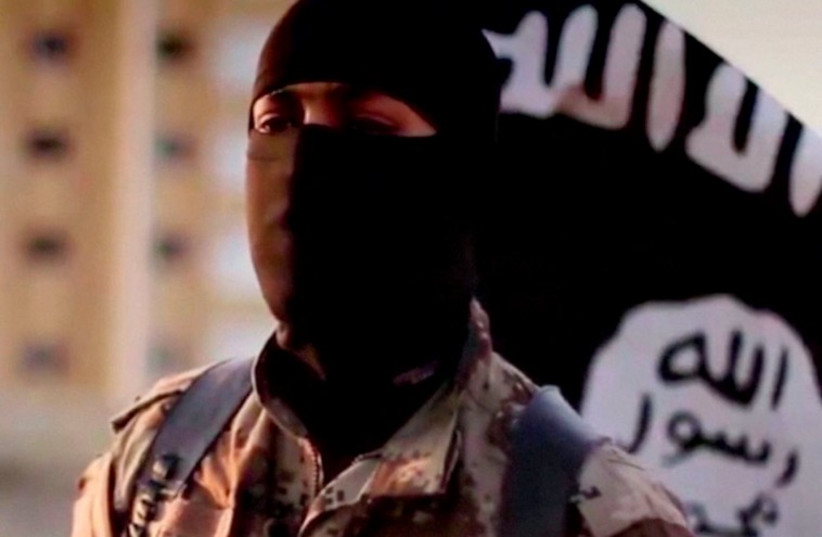 A masked man speaking in what is believed to be a North American accent in a video that Islamic State fighters released in September 2014. (photo credit: REUTERS)