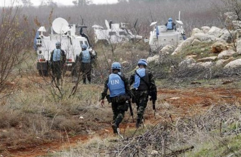 UNIFIL soldiers inspect remains of a shell launched from Lebanon into Israel (photo credit: REUTERS)