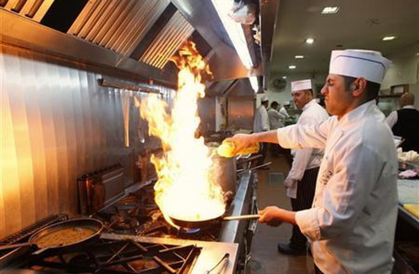 Palestinian chef prepares meal in a West Bank restaurant (photo credit: REUTERS)