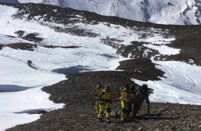 Nepalese army personnel drag the victims recovered after an avalanche at Thorang-La in Annapurna Region in this October 16, 2014. (photo credit: REUTERS)