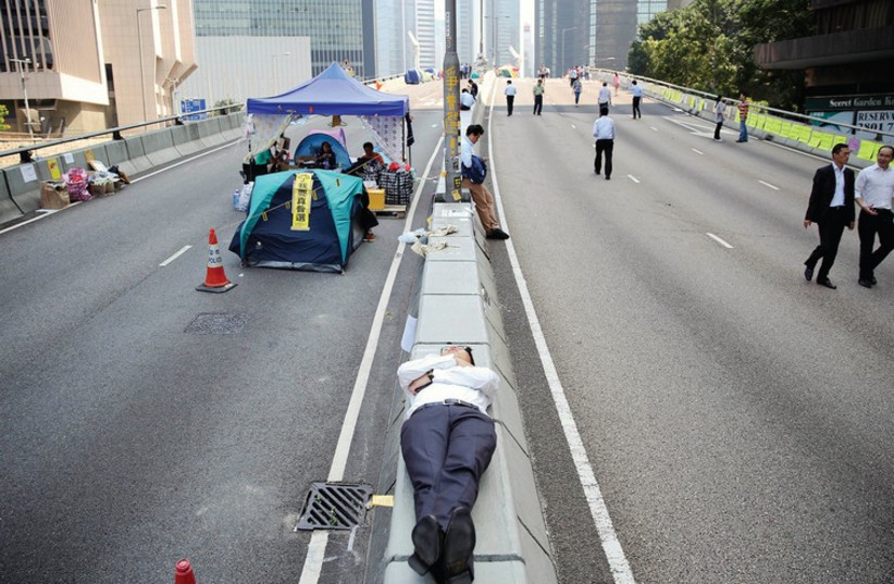 A MAN sleeps on a highway, perchance to dream (photo credit: REUTERS)