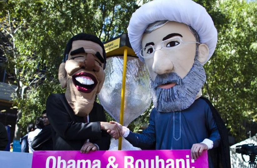 Members of international advocacy group Avaaz take part in a protest wearing masks of Iran's new President Hassan Rouhani (R) and US president Barack Obama, outside the UN headquarters in New York (photo credit: REUTERS)
